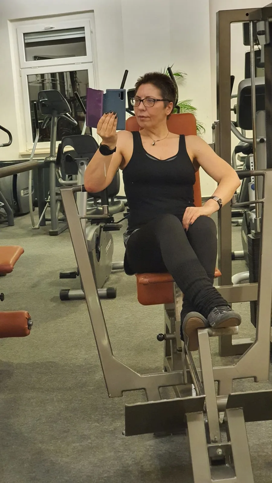 Sina Riegel sitzt auf einem Trainingsgerät im Fitnessstudio