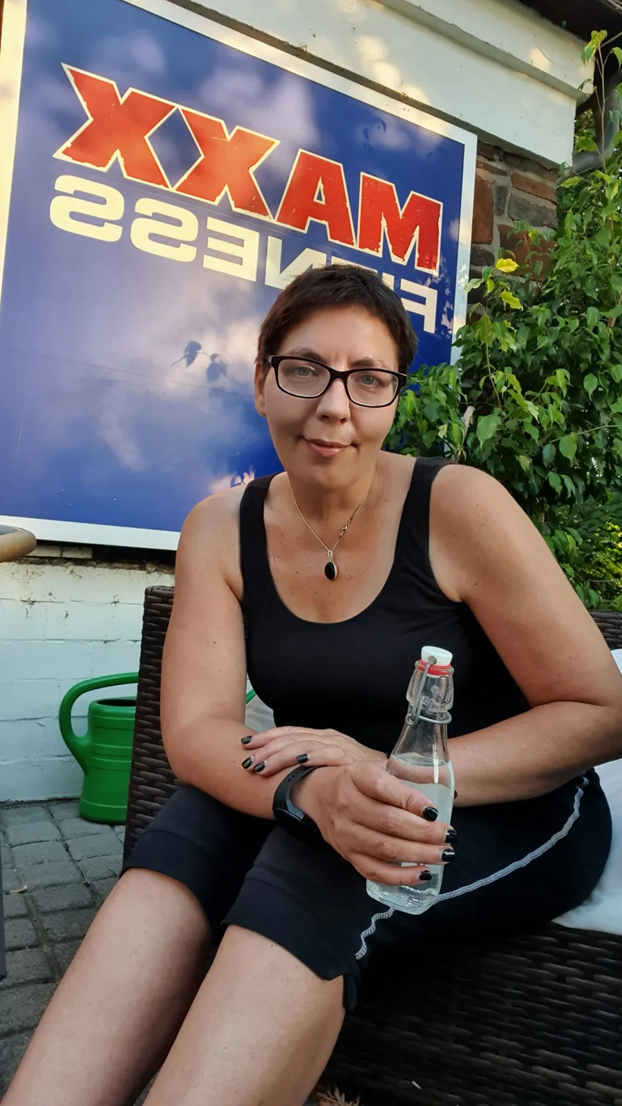 Sina Riegel mit einer Wasserflasche auf einer Terrasse